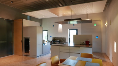 Objekt Dr. Resch in Krems Rehberg, Blick in die Küche OG über den Essplatz mit bunten Lichtöffnungen der ehemaligen Gerüstlöcher