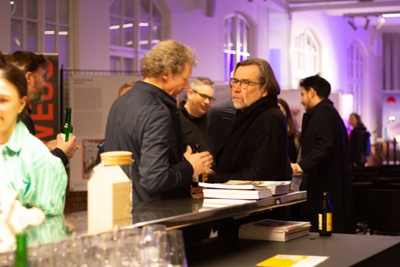 Die Gäste des Abends führen angeregte Gespräche über das Thema an der Bar.