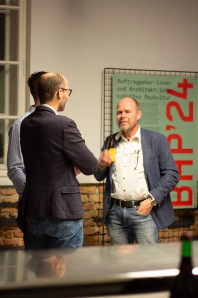 Die Gäste des Abends führen angeregte Gespräche über das Thema an der Bar.