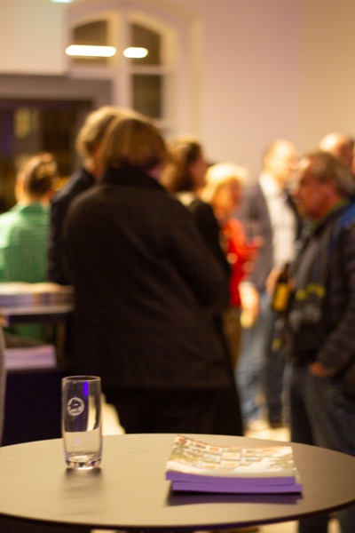 Die Gäste des Abends führen angeregte Gespräche über das Thema an der Bar.